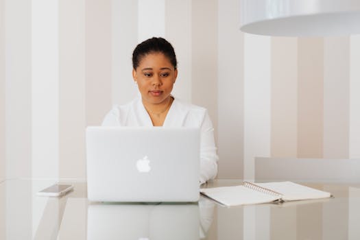 A focused workspace with a laptop and a notepad